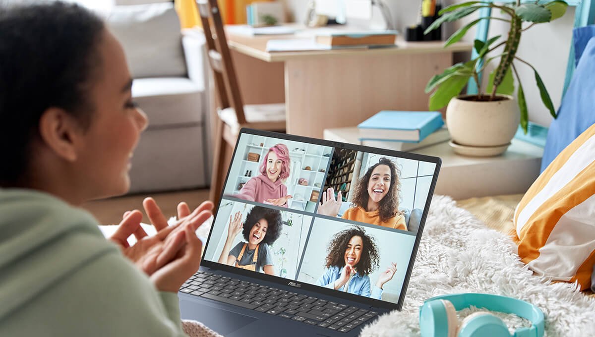 Een vrouw zit in een videogesprek met haar vrienden terwijl ze haar Asus Vivobook gebruikt.
