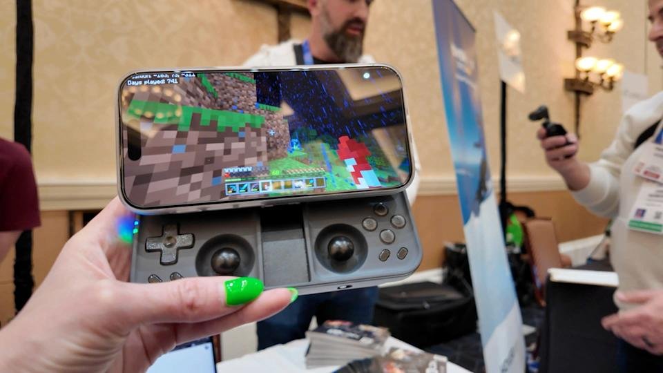 Engadget senior reporter Jessica Conditt houdt de OhSnap MCON op CES 2025. De verbonden telefoon geeft Minecraft weer.